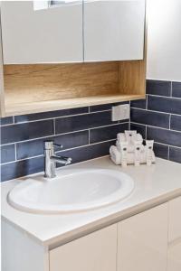 a white sink in a bathroom with blue tiles at Salty Sea Breeze Apartment 500m to waters edge in Gold Coast +17 photos