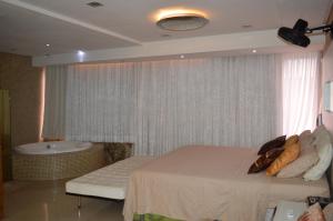 a bedroom with a bed and a bath tub at Apartamento Fortaleza Beira Mar in Fortaleza