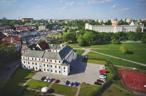 eine Luftansicht auf ein großes weißes Gebäude mit einem Parkplatz in der Unterkunft Dom na Podwalu in Lublin