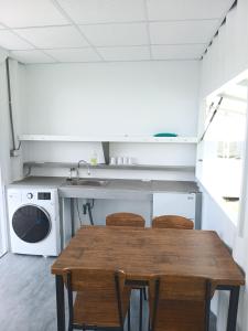 a kitchen with a table and a washing machine at 高一 33 班 Homestay 1982 in Chenggong