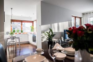 a kitchen and living room with a table with flowers at Apartment Extra Home in Kielce