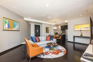 a living room with a couch and a table at Chatrium Hotel Riverside Bangkok in Bangkok