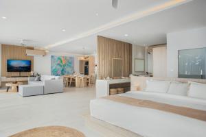 a bedroom with a large bed and a living room at Beachfront Secret Tides Villa Tierra in Koh Samui 