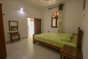 Un dormitorio con una cama y una mesa y una ventana. en Deluxe Double Room, en Unawatuna