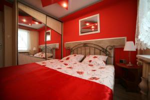 czerwona sypialnia z łóżkiem z czerwoną ścianą w obiekcie Apartamenty Podzamcze Wałbrzych w Wałbrzychu
