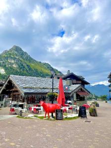 a red cow statue in front of a restaurant at ARC 1950 - Appartement 8 personnes Duplex Cheminée - ski aux pieds - Sauna, Hammam, Jacuzzi, Piscine in Arc 1950