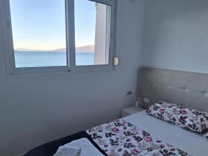 een slaapkamer met een bed en een raam bij Słoneczny brzeg in Sarandë