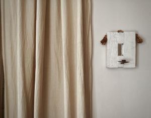 a curtain hanging on a wall next to a lightswitch at Bi&Babette in Cocconato