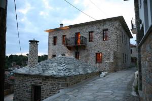 a large stone building with a balcony on top of it at Xenonas ton Chromaton in Lafkos