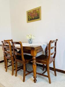 a wooden table with chairs and a vase of flowers on it at La casa di Regina in Tronzano Vercellese +19 photos