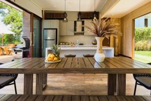 a kitchen and dining room with a wooden table at Selong Selo Resort and Residences in Selong Belanak