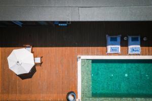 an overhead view of chairs and an umbrella and a swimming pool at Selong Selo Resort and Residences in Selong Belanak