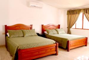 a bedroom with two beds and a window at Alborada Hotel Melgar in Melgar