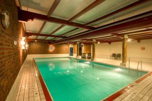 a large swimming pool in a building at Hotel Restaurant De Zwaan in Raalte