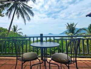 a table and chairs on a balcony with a view of the ocean at Mae Haad Sunset 2 in Koh Tao +4 photos