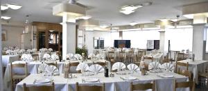 a room filled with tables and chairs with white table linen at Hotel San Crispino in Morrovalle