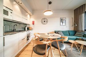 een keuken en woonkamer met een tafel en stoelen bij Ski Chalet C10 Levi Center incl 2 ski passes by Aavalevi in Levi +20 foto's