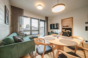 un soggiorno con un tavolo e un divano di Ski Chalet C10 by Aavalevi Holidays, Levi Center incl 2 ski passes a Levi