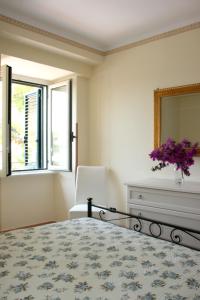 een slaapkamer met een bed, een spiegel en een stoel bij Residence Domus Cilento in Castellabate