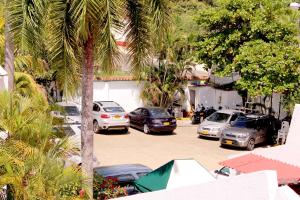 a group of cars parked in a parking lot with palm trees at Alborada Hotel Melgar in Melgar