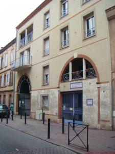 un gran edificio en una calle de la ciudad con un edificio en La Petite Auberge de Saint-Sernin, en Toulouse
