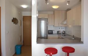 a kitchen with two red stools in front of a counter at Gorgeous Apartment In Torre Pacheco in Torre-Pacheco