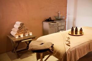 a bathroom with a bed and a table with towels and candles at Camvillia Resort Messinia in Vounaria