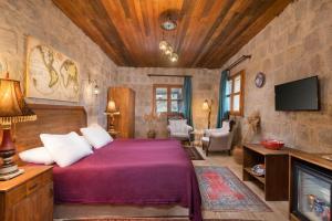 a bedroom with a bed and a tv in a room at World Cave House - Hotel & Swimming Pool in Ürgüp +81 photos