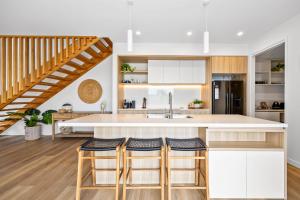 una cucina con bancone e scala di Bokarina 3-Bed Stunning Home, Steps from Beach a Kawana Waters