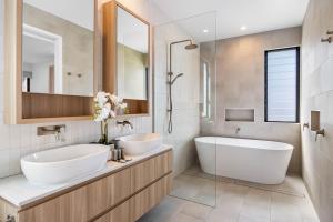 bagno con 2 lavandini, vasca e specchio di Bokarina 3-Bed Stunning Home, Steps from Beach a Kawana Waters Altre 12 foto