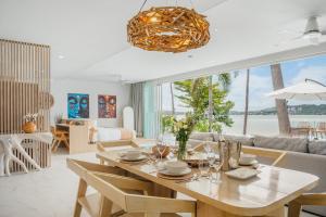 een eetkamer en woonkamer met een tafel en stoelen bij Beachfront Secret Tides Villa Luna in Koh Samui 