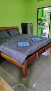 Una gran cama de madera en una habitación con espejo. en Lanta Ahad Apartments, en Ko Lanta