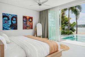een slaapkamer met een bed en een raam met een zwembad bij Beachfront Secret Tides Villa Luna in Koh Samui  +50 foto's