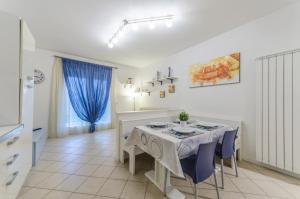 jadalnia ze stołem i niebieskimi krzesłami w obiekcie Residence Elisa Piano Terra con Giardino e Posto Spiaggia Incluso w Caorle