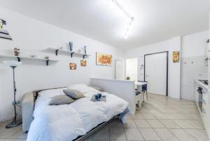 biała sypialnia z łóżkiem i biurkiem w obiekcie Residence Elisa Piano Terra con Giardino e Posto Spiaggia Incluso w Caorle