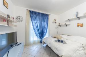 sypialnia z łóżkiem i zegarem na ścianie w obiekcie Residence Elisa Piano Terra con Giardino e Posto Spiaggia Incluso w Caorle