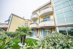budynek z palmą przed nim w obiekcie Residence Elisa Piano Terra con Giardino e Posto Spiaggia Incluso w Caorle