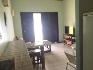 a living room with a table and chairs and a window at Ekoara Bangalos in Jacumã