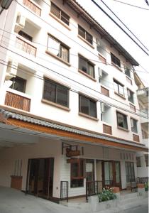 Gran edificio blanco con ventanas y balcón en Ban Wiang Guest House, en Chiang Mai