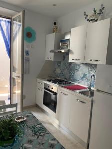 a kitchen with white cabinets and a sink and a stove at Case Vacanza Da Silvì in Agropoli