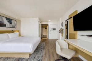 a hotel room with a bed and a desk at Hotel Preston Nashville Airport in Nashville