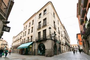 a building on a street with people walking around it at Apartamento con PARKING- Altior - Catedral Homes in Ávila