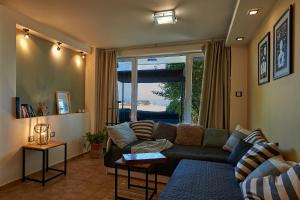 a living room with a couch and a large window at Guest House Dima in Sozopol