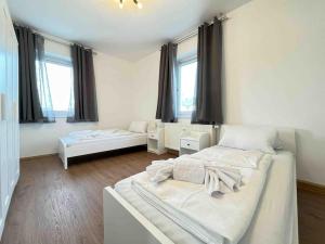 a white room with two beds and windows at SAD232 - Moderne Monteurwohnung Übergangswohnung in Schwandorf in Bayern