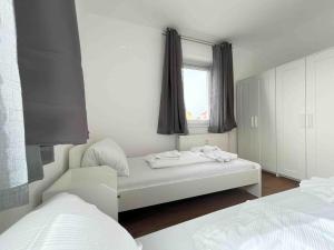 a bedroom with two beds and a window at SAD232 - Moderne Monteurwohnung Übergangswohnung in Schwandorf in Bayern +3 photos