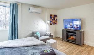 a bedroom with a bed and a flat screen tv at Newly Renovated Bright Studio in Rochester