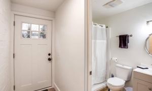 a white bathroom with a toilet and a shower at Newly Renovated Bright Studio in Rochester +27 photos