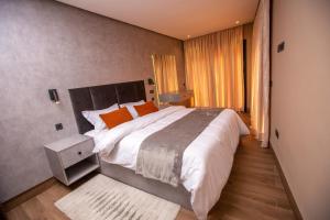 a bedroom with a large bed with orange pillows at Élégance et Prestige à Gueliz Appartement 3 chambres in Marrakech +51 photos