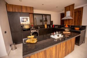 a kitchen with a black counter top and a sink at Élégance et Prestige à Gueliz Appartement 3 chambres in Marrakech