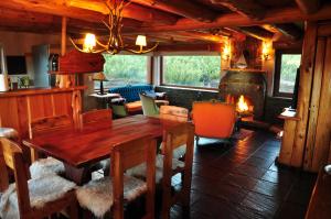 a dining room with a wooden table and a fireplace at Lodge Tikilen Caviahue in Caviahue